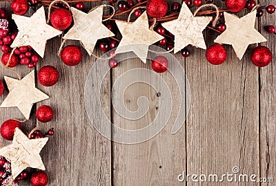 Christmas corner border with rustic wood star ornaments and baubles over aged wood Stock Photo