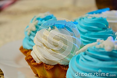 Christmas cream cakes and candles close up on the table with colored lights Stock Photo