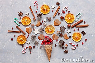 Christmas creativity concept with red balls, candy canes, cookies, spices, dry orange slices in the waffle. Flat lay, Close-up Stock Photo