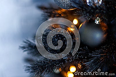 Christmas dark blurred background with a black Christmas tree, ornaments and bokeh lights Stock Photo