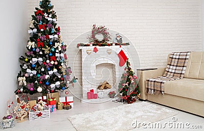 Christmas decor of bright stylish living room with vintage sofa, fireplace, Christmas tree and red candles, new year concept Stock Photo