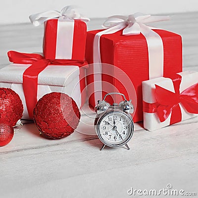 Christmas decorated red boxes gifts and alarm clock on wooden floor Stock Photo