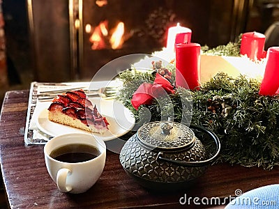 Christmas Decoration in Front of Fire Place with Damson Plum Tart Cake and Coffee Stock Photo