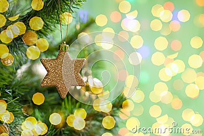 Christmas decoration golden twinkling star on a branch of a christmas tree, christmas tree toy, sparkling shiny background copy Stock Photo