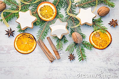 Christmas decoration over white wood background. Top view of homemade butter nuts star shaped cookies with icing, pine, orange Stock Photo