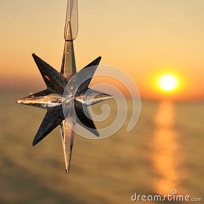 Christmas decoration star on the background of the sunset on the sea. Square Stock Photo