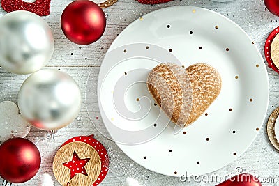 Christmas decoration with a white plate with gingerbread and baubles on a white table. Stock Photo