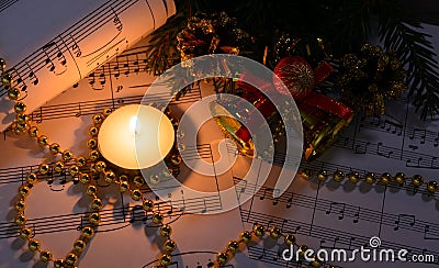 Christmas decorations, burning candle and sheet music Stock Photo