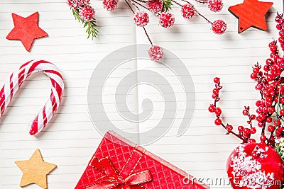 Christmas decorations, candy cane, frozen red berries, stars and gift box frame on notebook, copy space for text. Can be used for Stock Photo