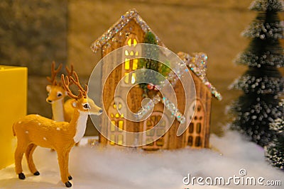 Christmas Decorations, Fluffy Reindeer, Tiny Wooden and Lighted Cottage Stock Photo