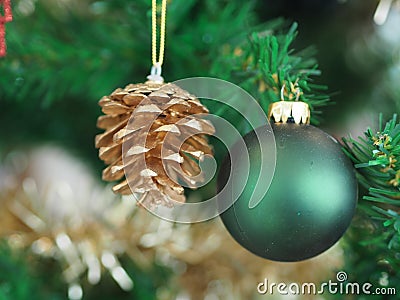 Christmas decorations green tree hanging, green ball, gold Pine cones, wrapped around it with a gold ribbon on white background Stock Photo