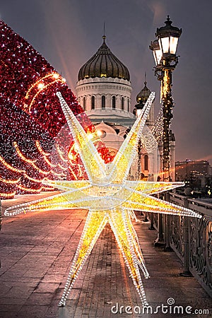 Christmas decorations on the Patriarch`s bridge on the background of the Cathedral of Christ the Savior in Moscow. Stock Photo