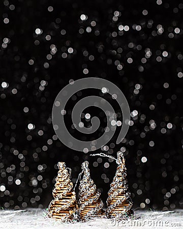 Christmas decorations view of three wooden tree colored in solver glitter at the tips and white hedgehog on dark background with Stock Photo