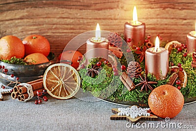 Christmas decorations - wreath with candles, bowl with oranges, wooden stars Stock Photo