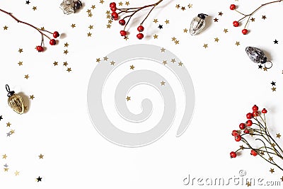 Christmas decorative frame, web banner. Red rose hips, vintage Christmas ornaments and golden confetti stars isolated on Stock Photo