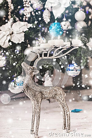 Christmas deer and Christmas tree background with decorations, snow, blurred, sparking, glowing. Stock Photo