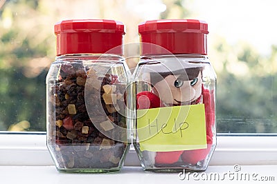 Christmas elf gets stuck in a jar. Stock Photo