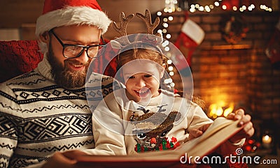 Christmas Eve. family father and child reading magic book at home Stock Photo