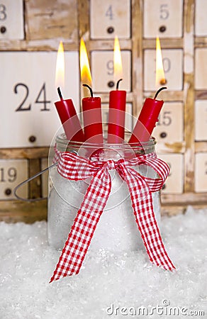 Christmas eve: four red burning candles with a shabby white advent calendar background Stock Photo