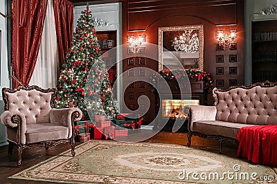 Christmas evening. classic apartments with a white fireplace, decorated tree, sofa, large windows and chandelier. Stock Photo