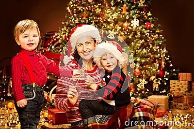 Christmas Family, Mother with Children front of Xmas Tree Lights, Happy Mom and Baby Stock Photo