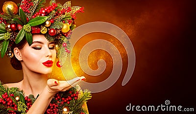 Christmas Fashion Model Beauty Makeup, Wreath Hairstyle. Xmas Woman Blowing to Hand, Beautiful Artistic Portrait Stock Photo