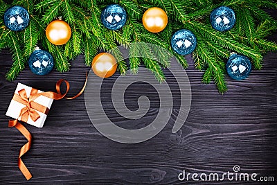 Christmas festive border, New Year decorative frame, golden and blue balls decorations on green fir branches, gift box on black Stock Photo