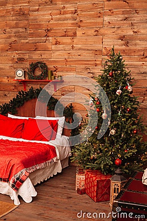 Christmas fir and the bed. New Year interior of room with bed and Christmas tree. Stock Photo