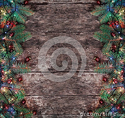 Christmas Fir branches with lights and red decorations on wooden background. Xmas and Happy New Year composition Stock Photo