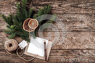 Christmas fir branches, paper card note, pencil and skein of jute on wooden background Stock Photo