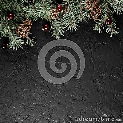 Christmas Fir branches with pine cones on dark black background. Xmas and Happy New Year card, bokeh, sparking, glowing. Stock Photo