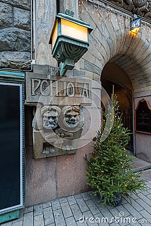 Christmas fir tree with lights garland and two soapstone trolls from Kalevala designed by Hilda Flodin on main entrance facade of Editorial Stock Photo