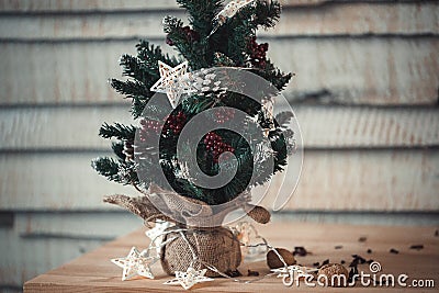 Christmas fir-tree on wooden background with light in star form for the design of a new year postcard. Flare copy space Stock Photo