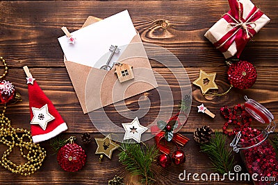 Christmas flat lay on a wooden background with keys to new house in the center with a envelope with a note sheet. New year, transf Stock Photo