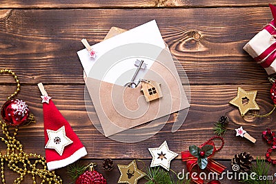 Christmas flat lay on a wooden background with keys to new house in the center with a envelope with a note sheet. New year, Stock Photo