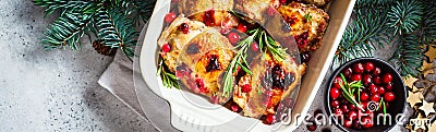 Christmas food. Baked Chicken meat with cranberries and rosemary in the oven dish, white background, banner Stock Photo