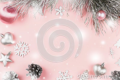 Christmas frame with fir branches, conifer cones, christmas balls and silver ornaments on pastel pink background Stock Photo