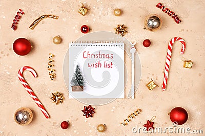 Christmas frame with red, golden holiday decorations and notebook with wish list. New year planning concept. Flat lay Stock Photo