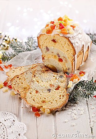 Christmas fruitcake with the addition of mixed candied fruits on a white wooden holiday table. Stock Photo