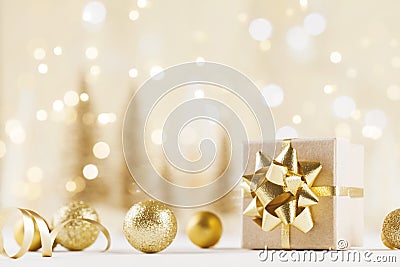 Christmas gift box against golden bokeh background. Holiday greeting card. Stock Photo