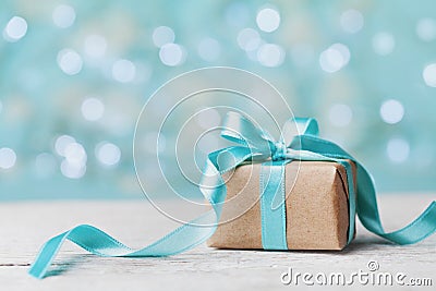 Christmas gift box against turquoise bokeh background. Holiday greeting card. Stock Photo