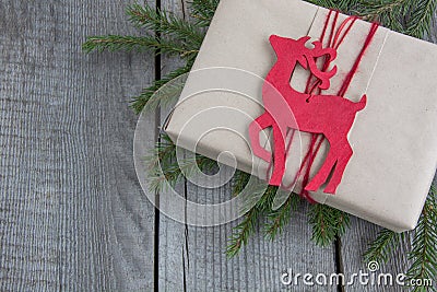 Christmas gift box on rustic table, decor reindeer, handicraft wrapping, parchment, fir tree twigs. Top view. Stock Photo