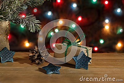 Christmas gift box in wrapping paper, stars and pinecone on background Stock Photo