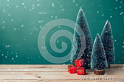 Christmas gift boxes under pine tree on wooden table over green background Stock Photo