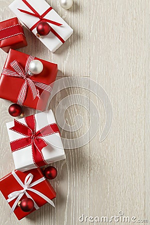 Christmas gifts presents on rustic wood background. Simple, red and white gift boxes festive holiday border. Stock Photo