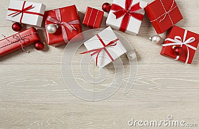 Christmas gifts presents on rustic wood background. Simple, red and white gift boxes festive holiday border. Stock Photo