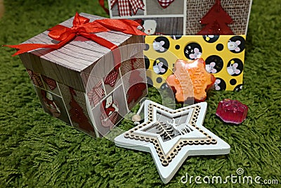 Christmas gifts, star, snowflake, mouse on the green grass Stock Photo