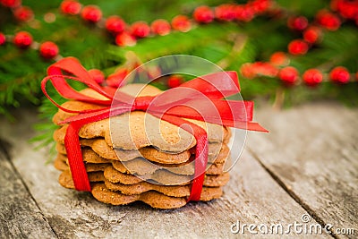 Christmas gingerbread cookies on a rustic wooden background with red ribbon Stock Photo