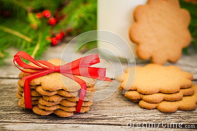 Christmas gingerbread cookies on a rustic wooden background with red ribbon Stock Photo