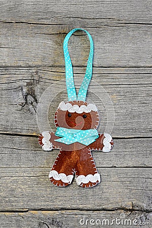 Christmas gingerbread man on old wooden background. Funny felt gingerbread man ornament. Christmas symbol. Top view Stock Photo